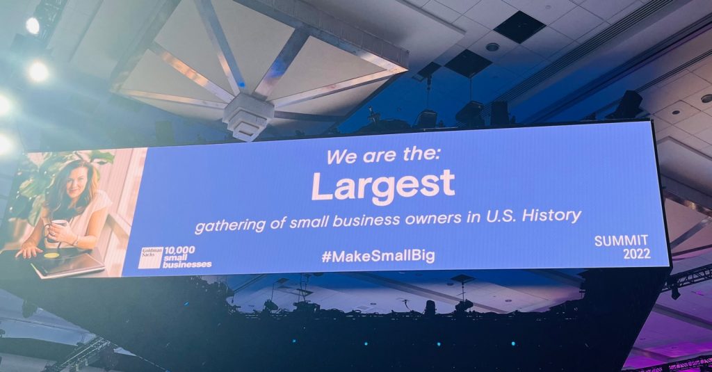 Sign reads: We are the largest gathering of small business owners in US history. #makesmallbig Summit 2022